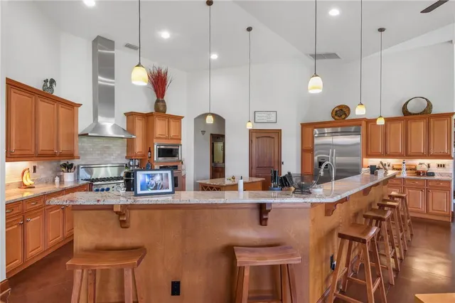 a kitchen with stainless steel appliances granite countertop a stove a sink and a refrigerator