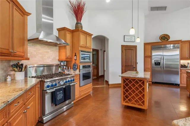 a large kitchen with granite countertop a sink and a refrigerator