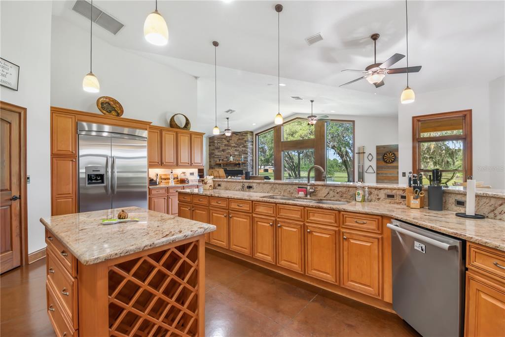 6140 Northwest 145th Avenue Road Morriston, FL 32668 - Photo 17 of 63 a large kitchen with granite countertop a sink and a refrigerator