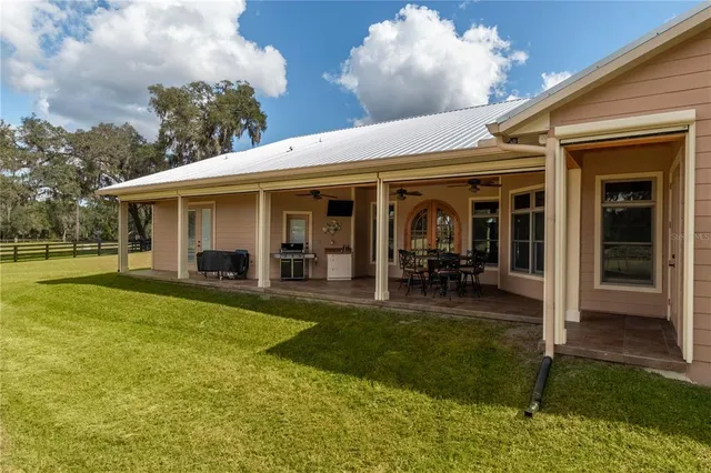 a view of a house with swimming pool and porch with furniture