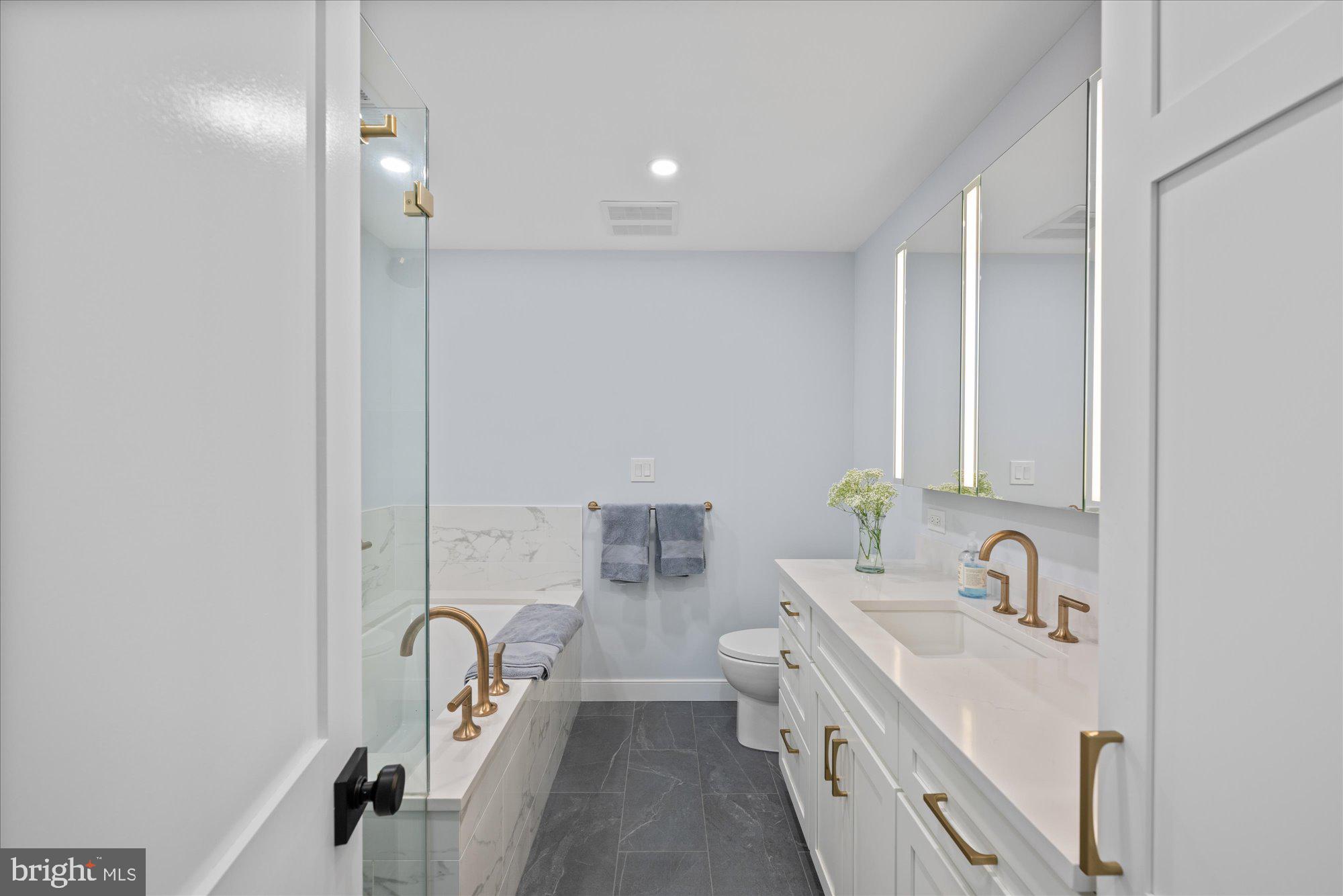 6700 Rannoch Road Bethesda, MD 20817 - Photo 21 of 36 a bathroom with a double vanity sink a mirror and a bathtub