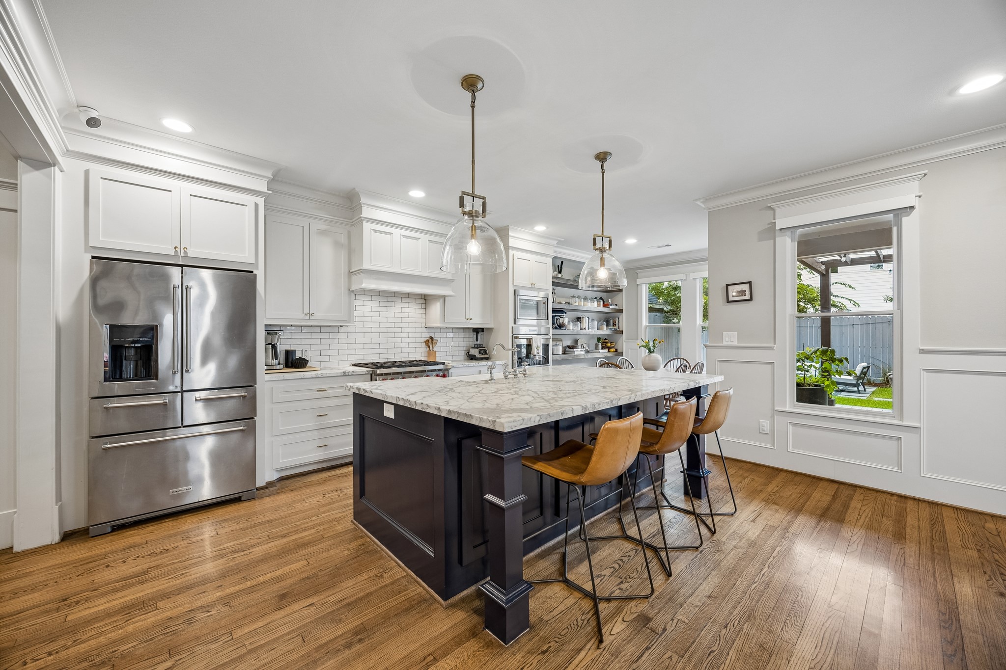 335 West 23rd Street Houston, TX 77008 - Photo 2 of 40 a kitchen with kitchen island wooden floors white appliances and center island