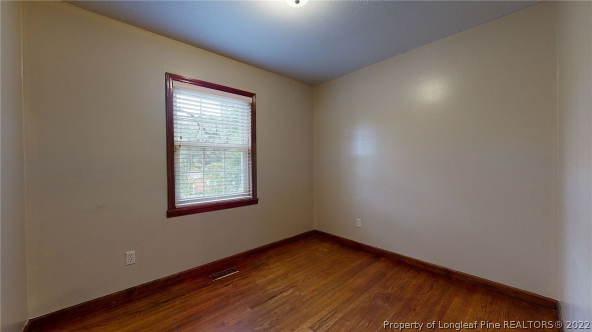 4311 Coventry Road Fayetteville, NC 28304 - Photo 12 of 22 an empty room with wooden floor and windows