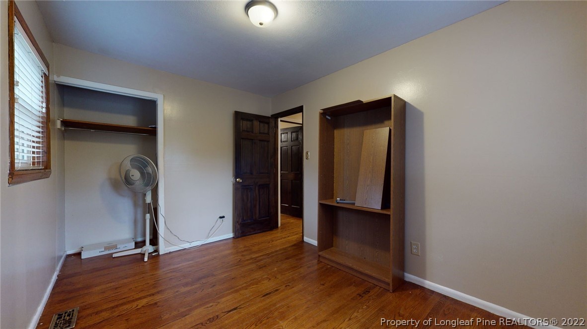 4311 Coventry Road Fayetteville, NC 28304 - Photo 13 of 22 an empty room with wooden floor and closet