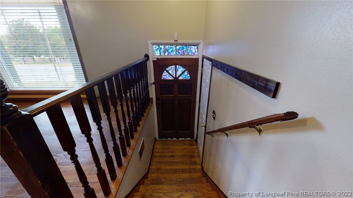 4311 Coventry Road Fayetteville, NC 28304 - Photo 6 of 22 a view of a hallway with wooden floor and stairs
