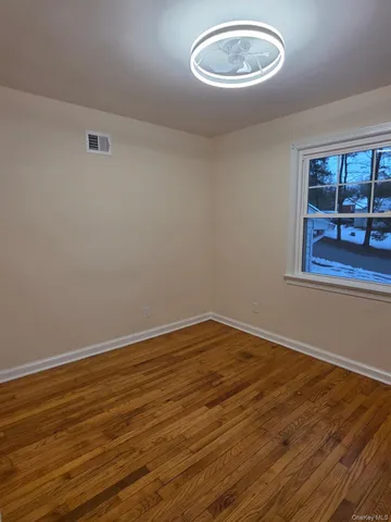 a view of a room with wooden floor and window