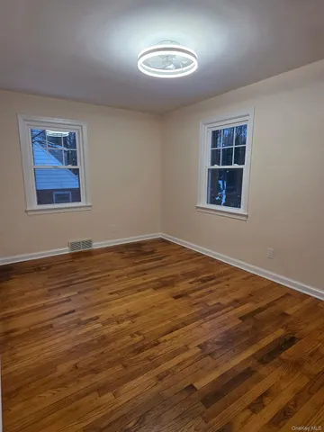 a view of a room with wooden floor and window