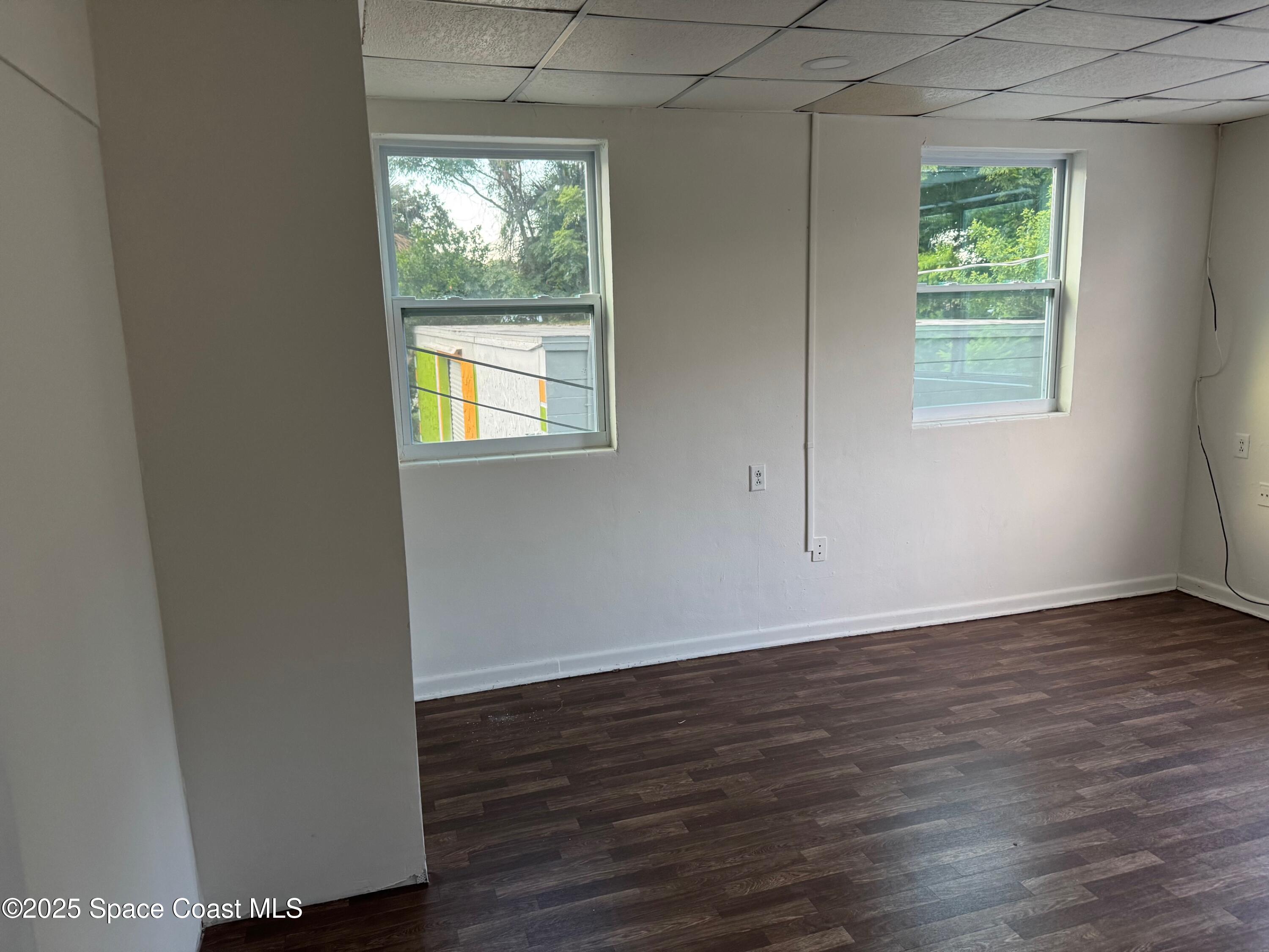 808 Forrest Avenue Cocoa, FL 32922 - Photo 7 of 11 an empty room with wooden floor and windows