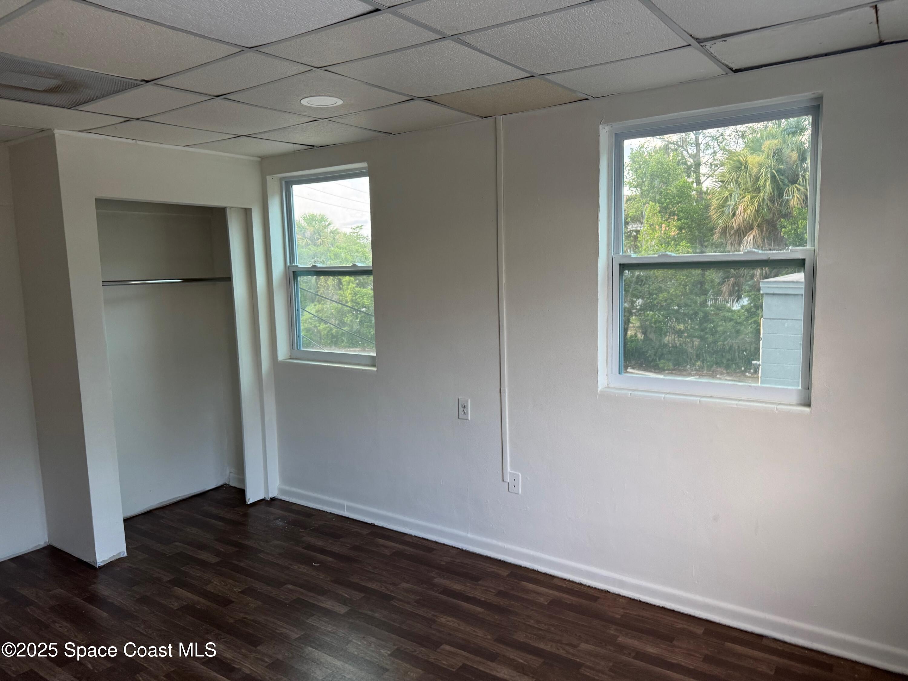 808 Forrest Avenue Cocoa, FL 32922 - Photo 9 of 11 an empty room with wooden floor and windows