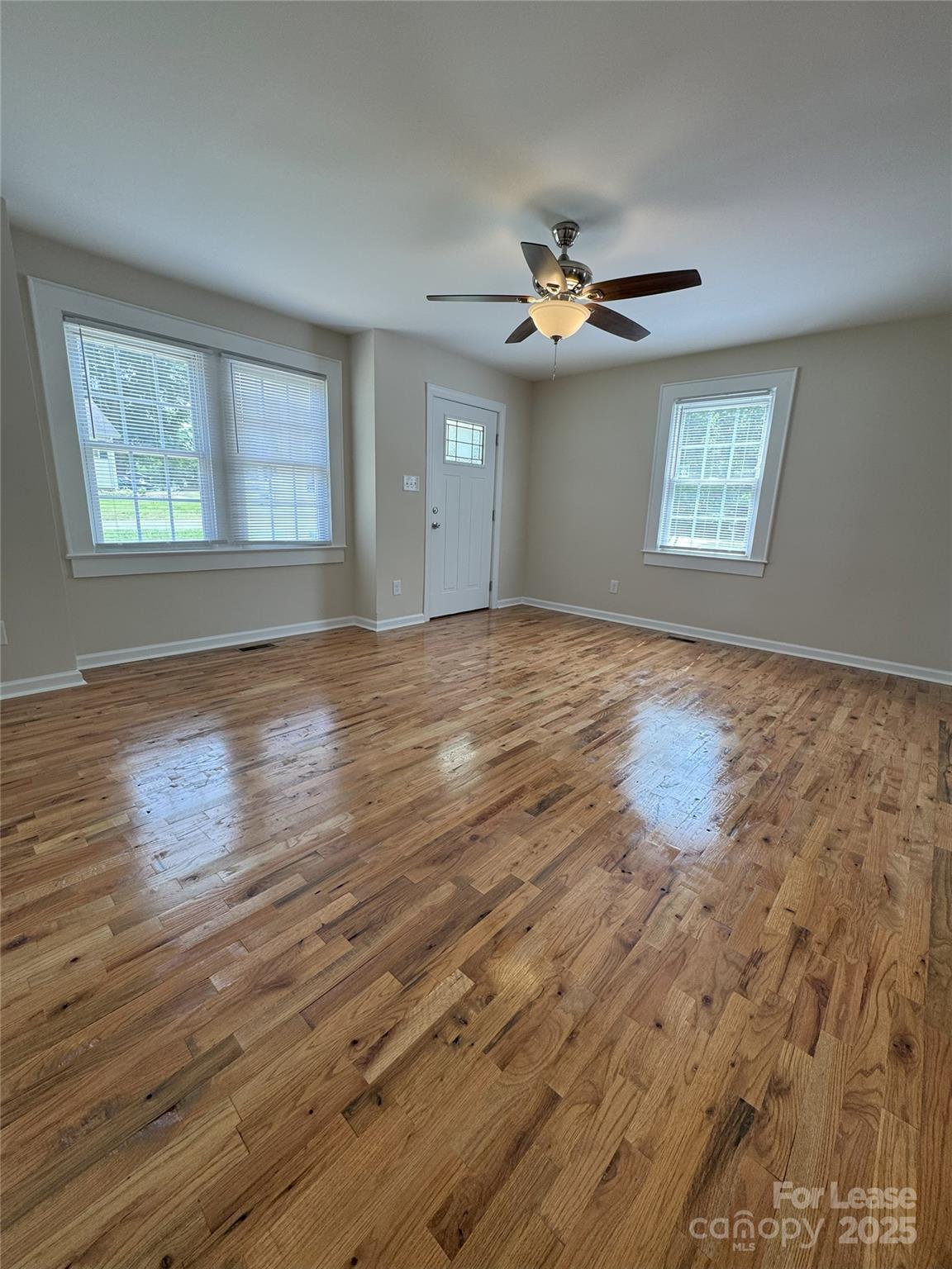 60 3rd Street Concord, NC 28025 - Photo 7 of 10 an empty room with wooden floor ceiling fan and windows