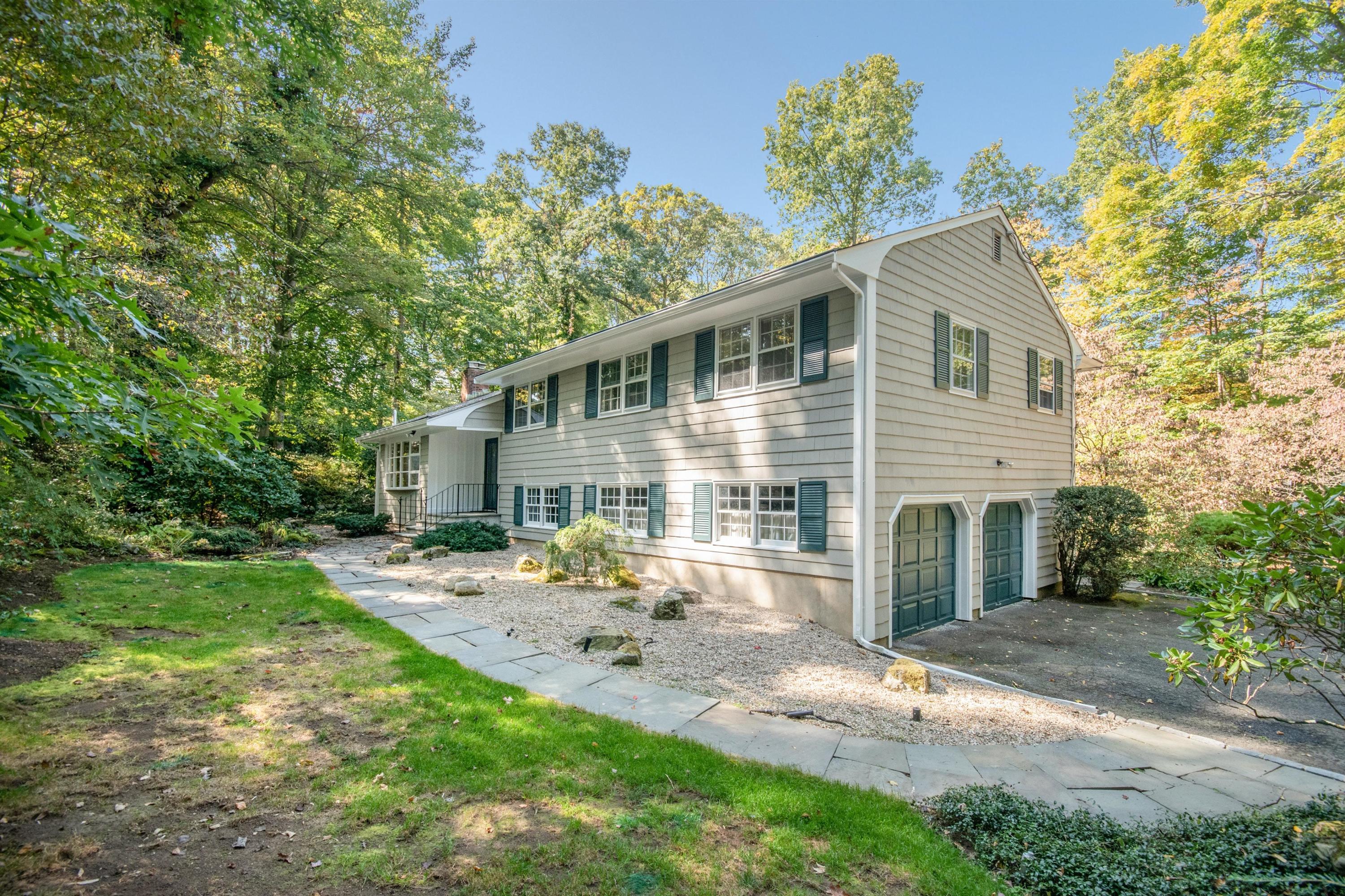 54 Huckleberry Hill Road New Canaan, CT 06840 - Photo 2 of 37 a front view of a house with garden