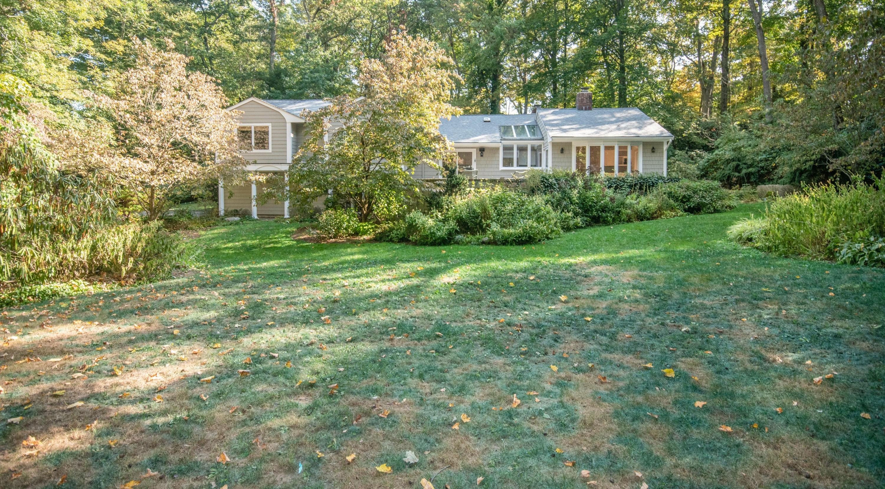 54 Huckleberry Hill Road New Canaan, CT 06840 - Photo 32 of 37 a view of a big yard next to a house