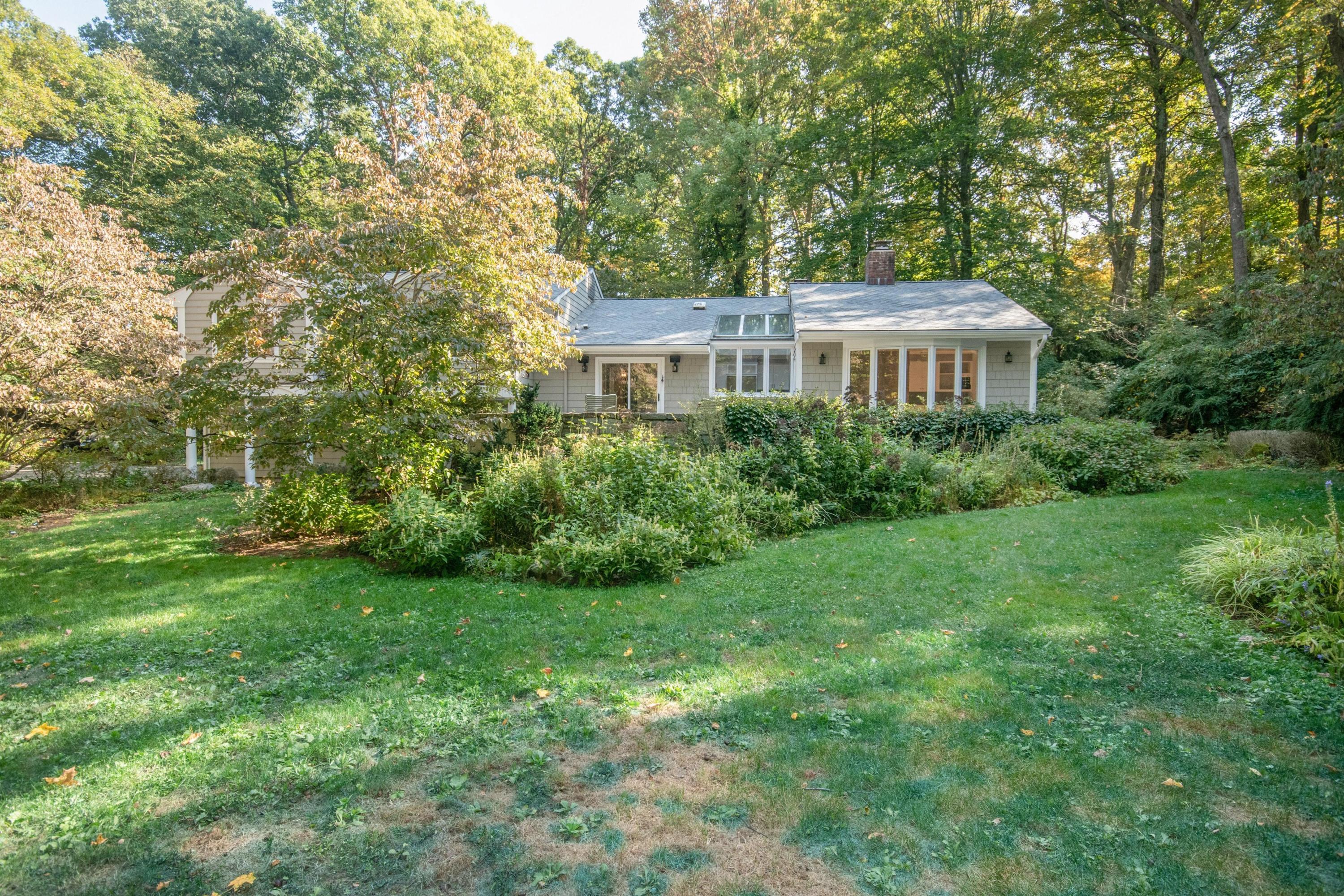 54 Huckleberry Hill Road New Canaan, CT 06840 - Photo 33 of 37 a view of a big yard next to a house