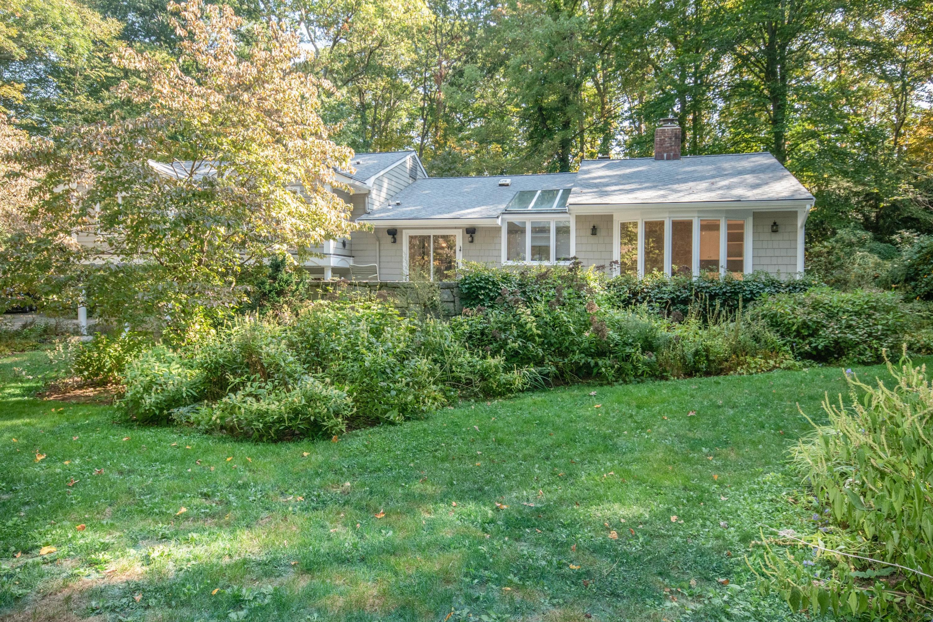 54 Huckleberry Hill Road New Canaan, CT 06840 - Photo 34 of 37 a front view of a house with a garden