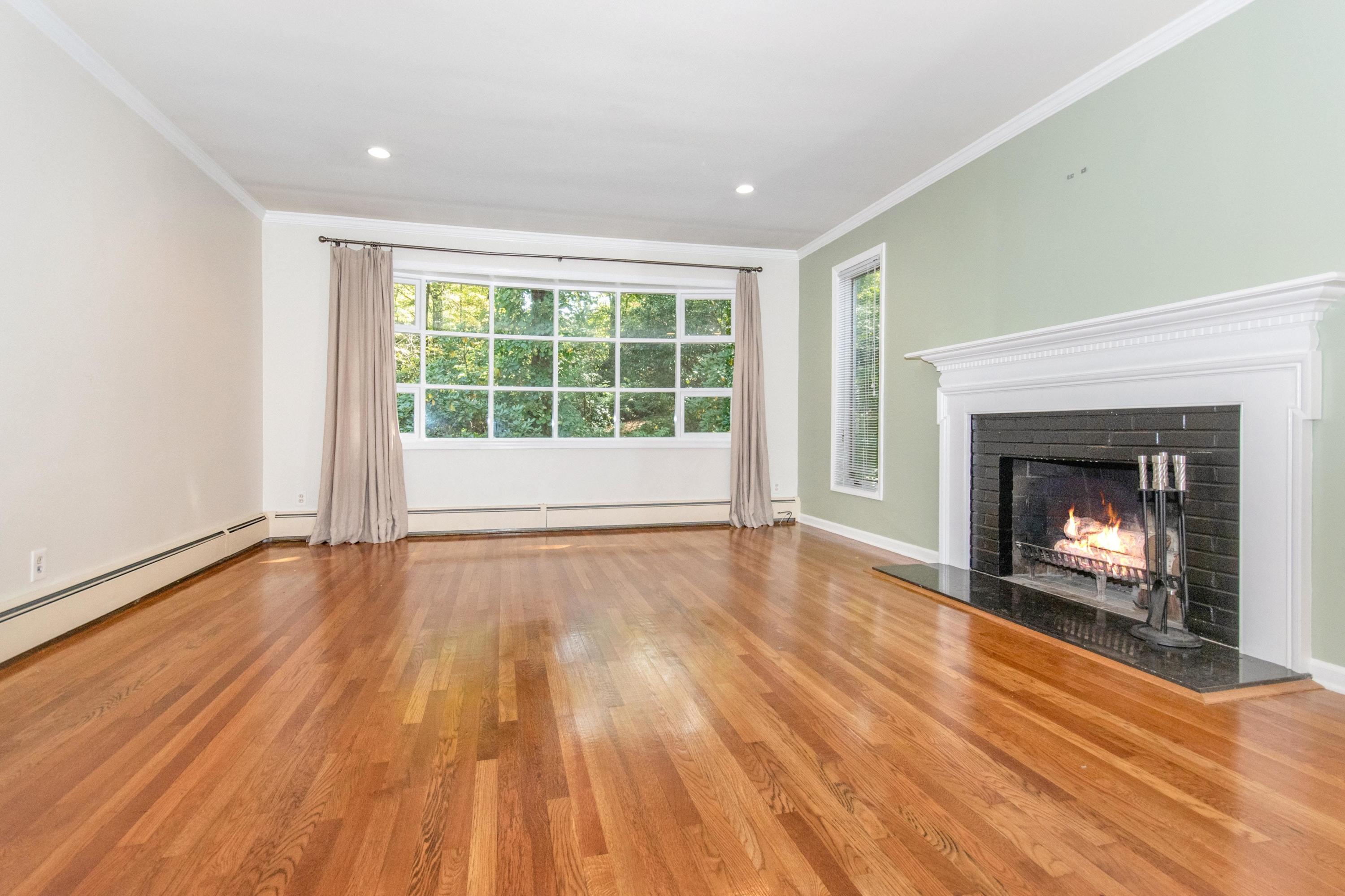 54 Huckleberry Hill Road New Canaan, CT 06840 - Photo 7 of 37 an empty room with wooden floor fireplace and windows