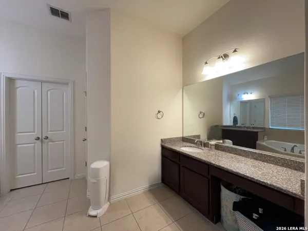 a bathroom with a granite countertop sink and a mirror