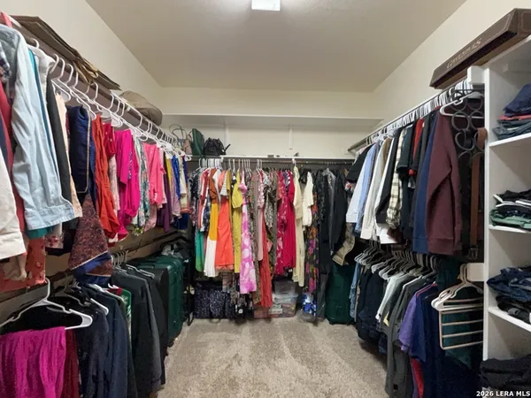 a view of walk in closet with clothes
