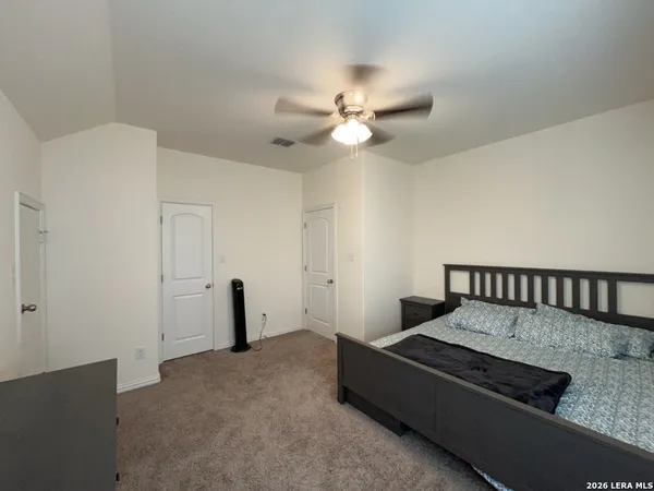 a bed room with furniture and a ceiling fan