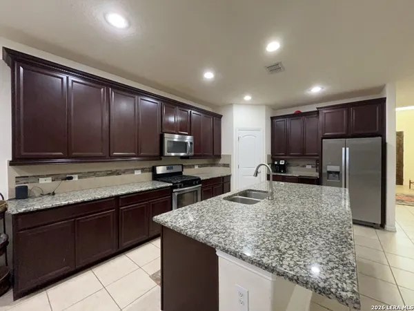 a kitchen with stainless steel appliances granite countertop granite counter tops refrigerator and cabinets