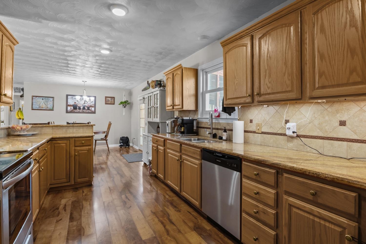 41 Golden Pond Circle Holladay, TN 38341 - Photo 14 of 42 a kitchen with stainless steel appliances granite countertop wooden cabinets a sink and dishwasher a stove top oven with wooden floor