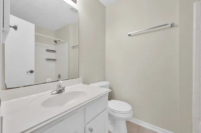 a view of an empty room and chandelier fan