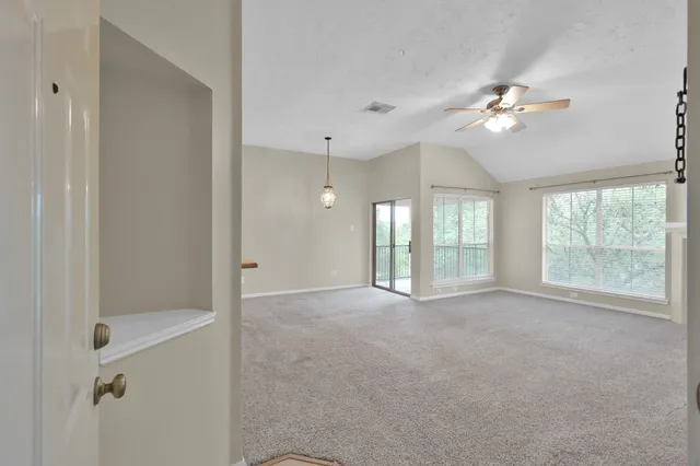 a view of empty room with fan and window
