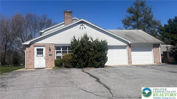 a view of house with garage and small yard