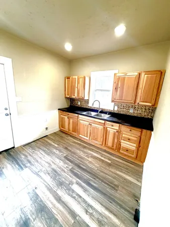 a view of a kitchen with wooden floor and a sink