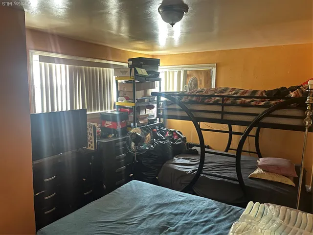 a bedroom with a bed table and window