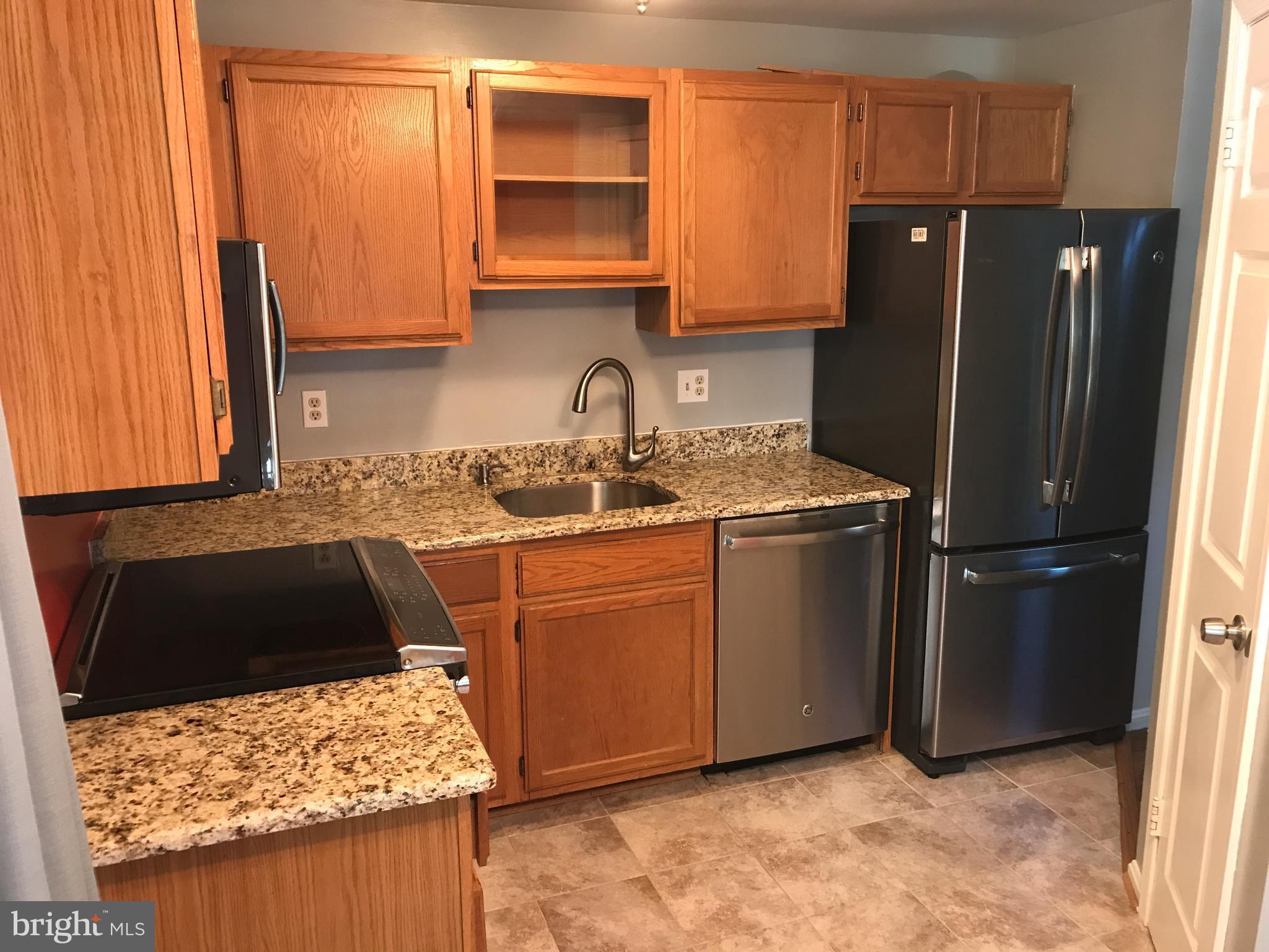 1717 Whisperhill Drive Reston, VA 20194 - Photo 3 of 10 a kitchen with stainless steel appliances granite countertop a refrigerator stove and sink