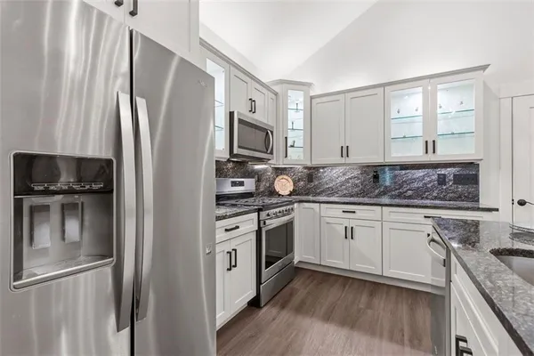 a kitchen with stainless steel appliances granite countertop a refrigerator stove and sink