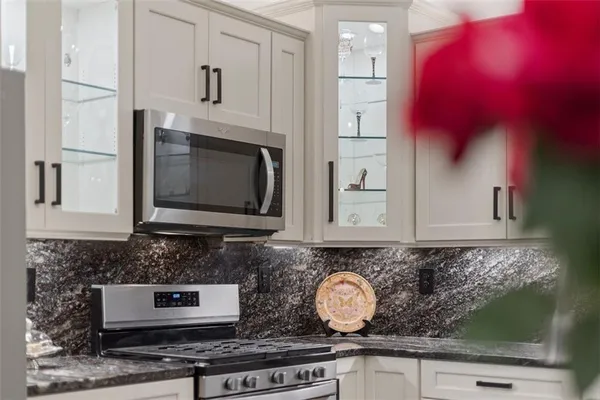 a kitchen with stainless steel appliances granite countertop a stove a microwave and cabinets
