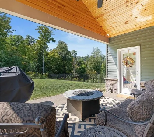 a view of a backyard with table and chairs couches and wooden fence