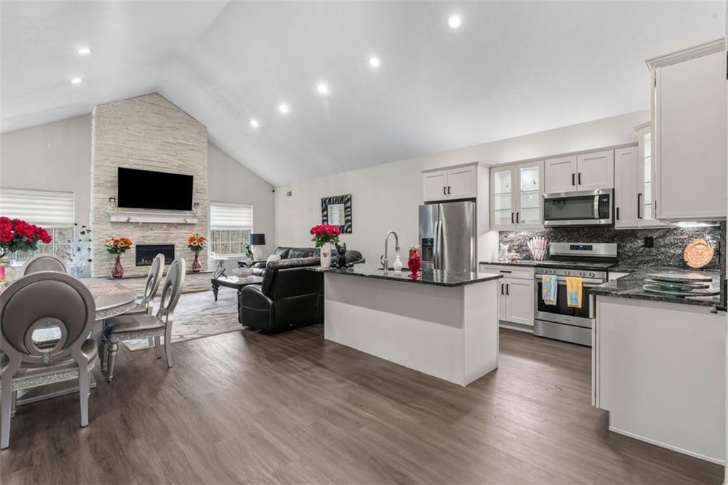 113 Hemingway Lane Coraopolis, PA 15108 - Photo 6 of 44 a living room with furniture a flat screen tv and kitchen view