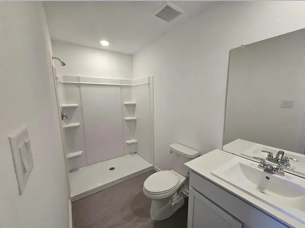 a bathroom with a granite countertop sink toilet and shower