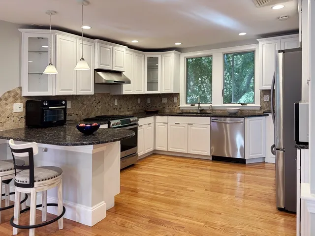 a kitchen with stainless steel appliances granite countertop a stove a sink and a microwave