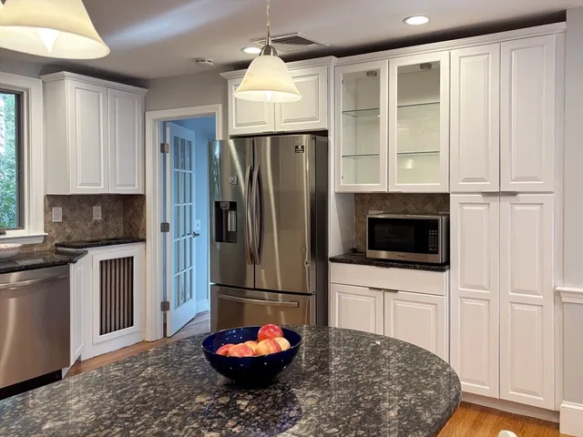 a kitchen with stainless steel appliances granite countertop a refrigerator sink and microwave