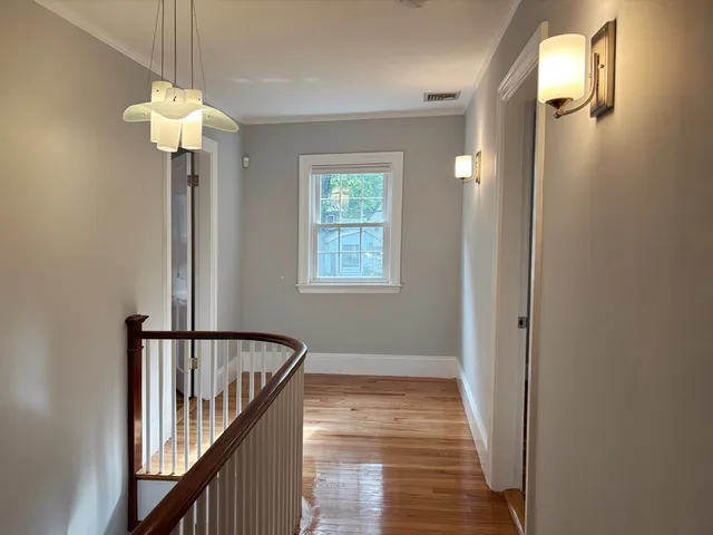 a view of a hallway with windows and chandelier