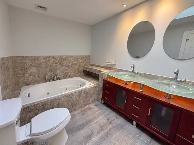 a bathroom with a granite countertop double vanity sink and a mirror