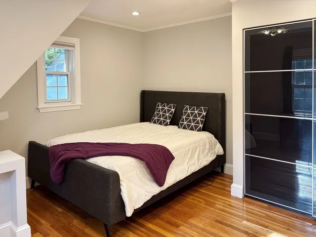 a large bed sitting in a bedroom next to a window and a mirror