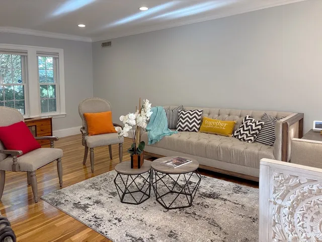 a living room with furniture and wooden floor