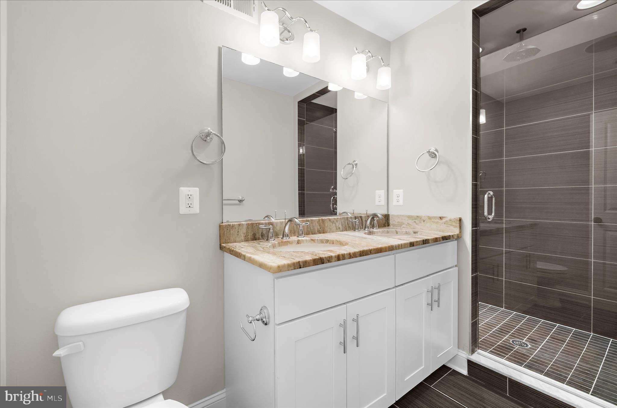 932 South Clinton Street Baltimore, MD 21224 - Photo 23 of 46 a bathroom with a granite countertop sink a toilet and a mirror