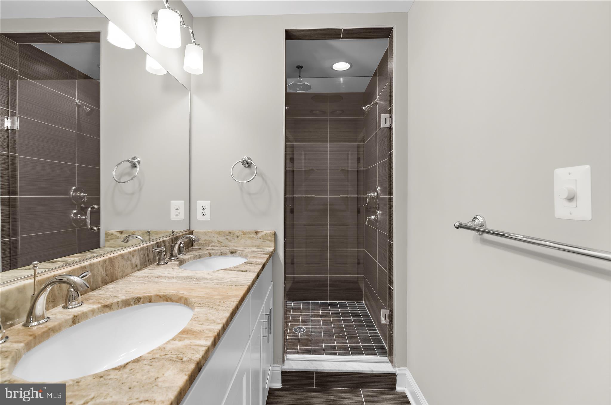 932 South Clinton Street Baltimore, MD 21224 - Photo 24 of 46 a bathroom with a granite countertop sink a mirror and shower