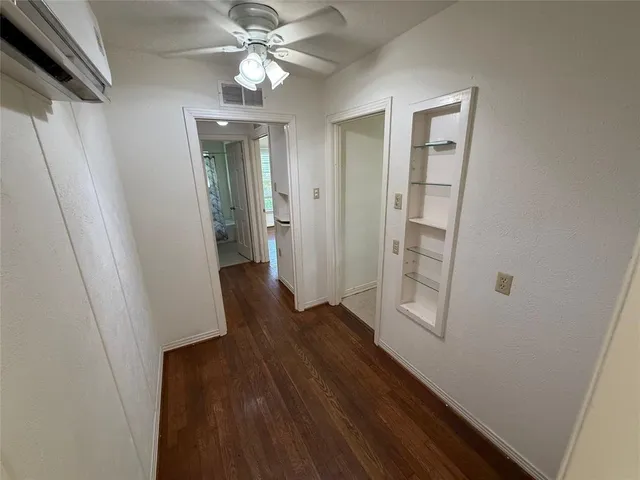 a view of a hallway with wooden floor