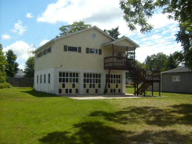 a view of a house with a big yard and large trees