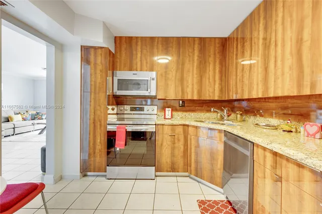 a kitchen with stainless steel appliances granite countertop a refrigerator and a stove
