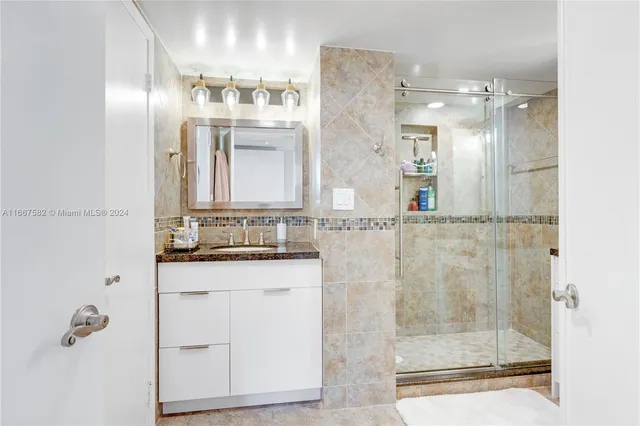 a bathroom with a shower sink and mirror