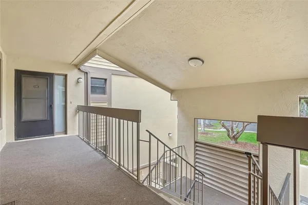 a view of a hallway with wooden floor and stairs