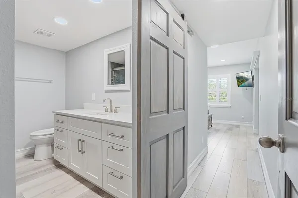 a spacious bathroom with a double vanity sink a toilet and a mirror