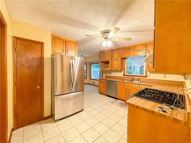 a kitchen with stainless steel appliances granite countertop a refrigerator and a stove